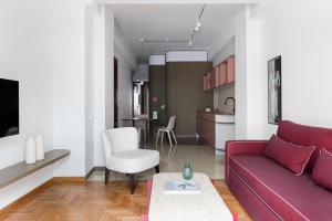 雅典Nileos House的客厅配有红色沙发和白色椅子