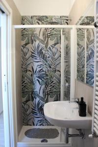 因佩里亚Casa Vacanze Merletto的浴室设有水槽和蓝色及白色的壁纸