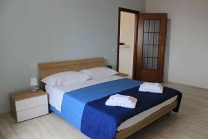 因佩里亚Casa Vacanze Merletto的一间卧室配有一张大床和两条毛巾