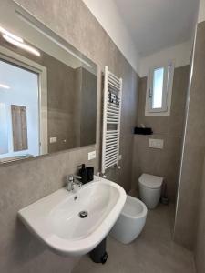 因佩里亚Casa Vacanze Merletto的一间带水槽、卫生间和镜子的浴室