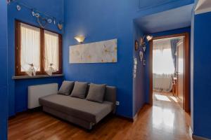 特拉诺瓦-布拉乔利尼Villa Lolù的客厅拥有蓝色的墙壁和沙发