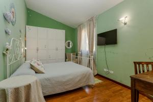 特拉诺瓦-布拉乔利尼Villa Lolù的一间卧室设有绿色的墙壁、一张床和一张桌子