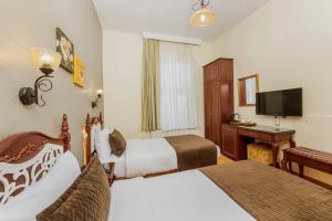伊斯坦布尔伊佩克帕拉斯酒店的酒店客房配有两张床和一张书桌