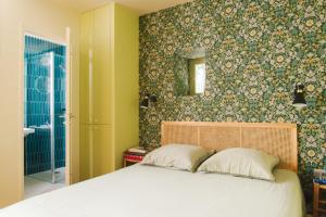 巴黎Le Grand Maulnes的一间卧室设有一张床和绿色的墙壁