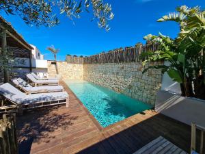 埃斯·梅卡达尔S´Estancia Suites的一个带躺椅和石墙的游泳池