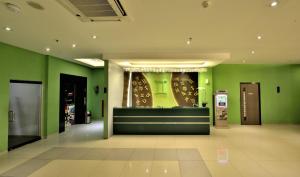 雅加达Zodiak MT Haryono by KAGUM Hotels的拥有绿色墙壁和现金登记册的商店大堂