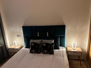卡萨布兰卡CHIC & COZY appartement très calme的一间卧室配有一张带蓝色床头板的床和两张桌子