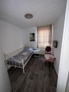 GronauDemir Pension的一间小卧室,配有一张床和一把椅子