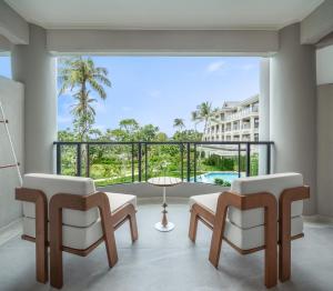 查汶Centara Reserve Samui - SHA Plus的客厅配有两把椅子和大窗户