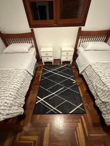 圣若泽杜斯坎普斯Casa Jardim das Colinas的两张睡床彼此相邻,位于一个房间里