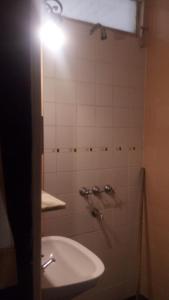 圣达菲Emperatriz HOTEL familiar的浴室配有水槽和墙上的灯。