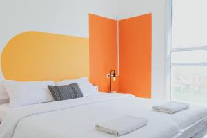 耶鲁姆The White Hill Guesthouse的一间卧室配有一张白色床和橙色床头板