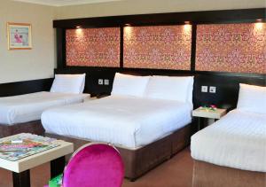 戈尔韦弗兰尼瑞斯酒店的酒店客房,设有两张床和一张粉红色的椅子