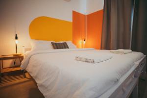 耶鲁姆The White Hill Guesthouse的一间卧室配有一张白色大床和橙色床头板