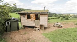 斯卡伯勒Shepherds Hut by Stepney Stays的一座带梯子和长凳的小房子