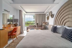 圣帕拉斯凯维Arco Beach Hotel的一间卧室配有一张床、一张桌子和一张沙发