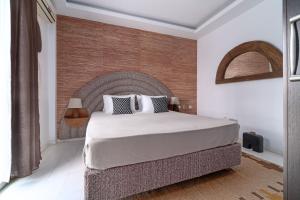 圣帕拉斯凯维Arco Beach Hotel的一间卧室设有一张大床和砖墙