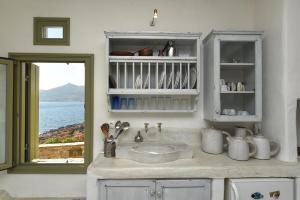 纳乌萨Ochre Dream, Beach front & Sunset villa Naousa的带水槽的厨房台面和窗户