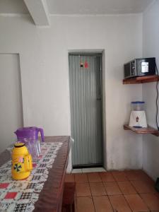 迪亚曼蒂纳Casa em Diamantina的一间设有桌子的房间和带微波炉的门