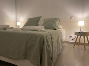 巴拉吕克莱班Le petit prince的一间卧室配有一张带绿色床单的床和一张桌子