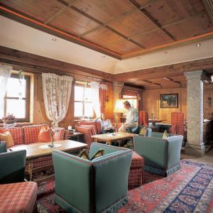 瑟弗浩斯Hotel Garni Serfauserhof的坐在餐厅里的人,有桌椅