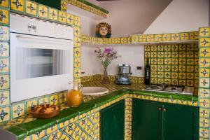 陶尔米纳卡萨安德烈住宿加早餐旅馆的厨房配有绿色橱柜和黄色瓷砖