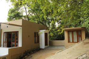 康提Kandy Lotus House的前面有一棵树的小房子