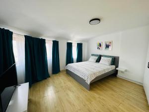 布加勒斯特Turqoise Central Apartaments的一间卧室配有一张带蓝色窗帘的床,铺有木地板