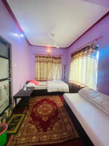 班迪普尔Himchuli Guest House的紫色墙壁和地毯的客房内的两张床