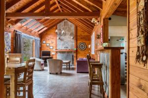 拉安戈斯图拉镇BOG Melania - casa en el bosque的一间厨房和带木墙及天花板的用餐室