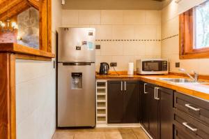 拉安戈斯图拉镇BOG Melania - casa en el bosque的厨房配有不锈钢冰箱和微波炉。