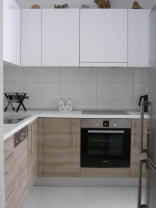 斯普利特Momentum Apartment的厨房配有白色橱柜和黑烤箱。