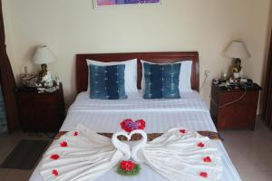 乌布Sunset Pandawa Villa的一间卧室配有一张带两只天鹅的毛巾床