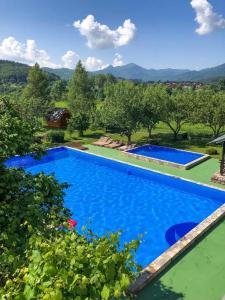 科拉欣Blue Village Lux的背景是一座游泳池,山地环绕