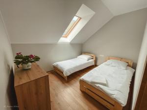 奥克宁卡Apartamenty Grey的一间卧室设有两张床、一张桌子和一个窗口