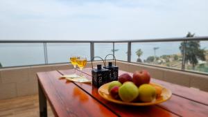 提比里亚Galilee Triple Terrace的一张桌子,上面放着一盘水果和酒
