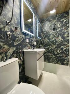 科拉欣Blue Village Lux的一间带水槽和绿叶壁纸的浴室