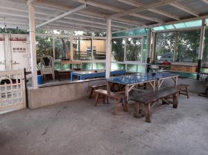 车城垦丁海生馆-海泊旅宿的一间设有两张乒乓球桌和长凳的房间