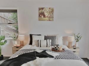 RosettaModern holiday home in Hobart - Stunning Mountain & Water views的一间卧室配有一张带黑白枕头的床