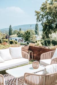 珀内代皮耶罗曼迪卡酒店的庭院设有白色的沙发和草地上的椅子