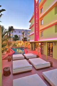 普拉亚登博萨Tropicana Ibiza Suites - Adults Only的游泳池前的床位酒店