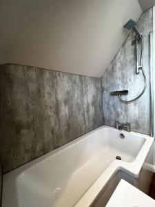 罗斯林Roslin Templar loft的带浴缸的浴室和混凝土墙