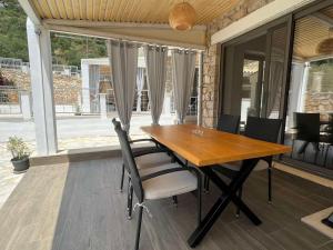 阿约斯尼奇塔斯Lavender Villas Agios Nikitas , Lefkada的天井上的木制餐桌和椅子