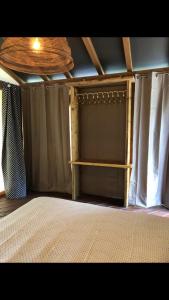 塞拉瓦莱皮斯托耶塞AgriGlamping La Diaccia的一间卧室设有床、窗帘和天花板