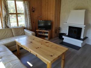 卑尔根Fanafjorden Cabins的客厅配有咖啡桌和壁炉