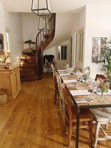 Saint-AlvèreDIX Restaurant & Chambres d'hotes的一间带桌椅和楼梯的用餐室