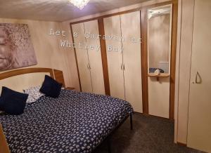 惠特利湾Let's Caravan at Whitley Bay的一间卧室,卧室里配有一张床和一个标志,上面写着野生动物湾的大篷车