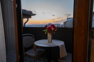 伊斯坦布尔Pera Luna Premium Hotel的花瓶坐在阳台上的桌子上