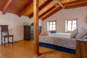 托尔明Country House Lastovka的一间卧室设有一张床和木制天花板