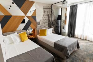 布尔加斯MM Boutique Hotel的酒店客房 - 带两张带黄色枕头的床